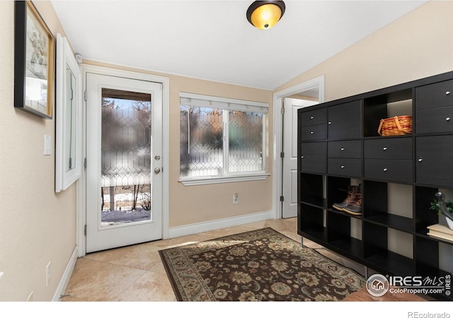 entryway featuring lofted ceiling and light tile patterned flooring