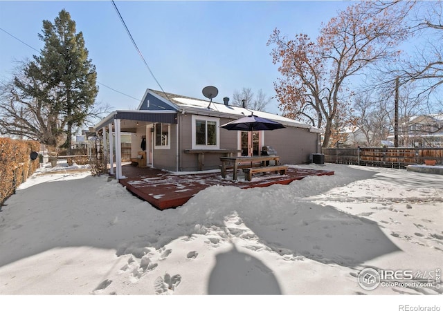 snow covered house with central air condition unit