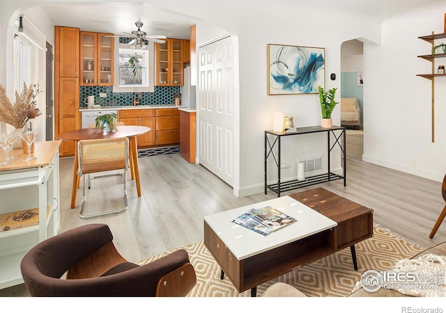 living room with ceiling fan and light hardwood / wood-style flooring