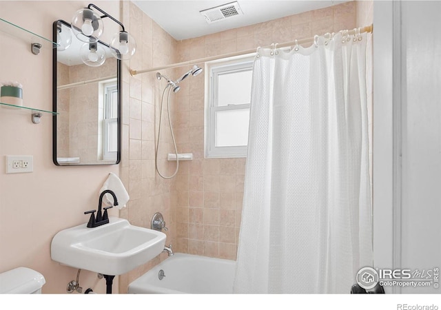 full bathroom featuring shower / tub combo, toilet, and sink