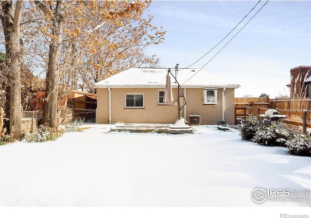 snow covered house featuring central air condition unit