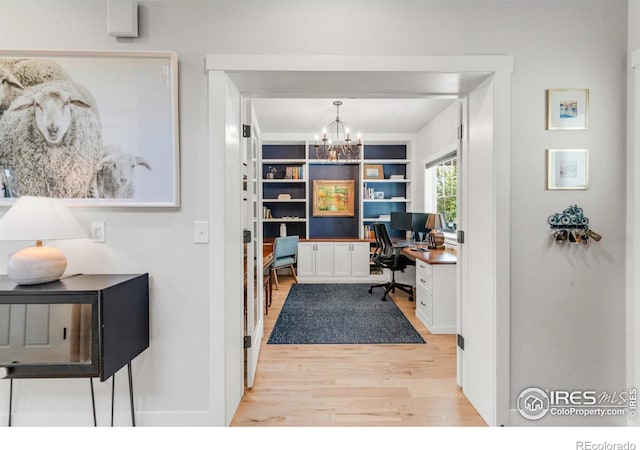 office area featuring built in features, a notable chandelier, and light hardwood / wood-style floors