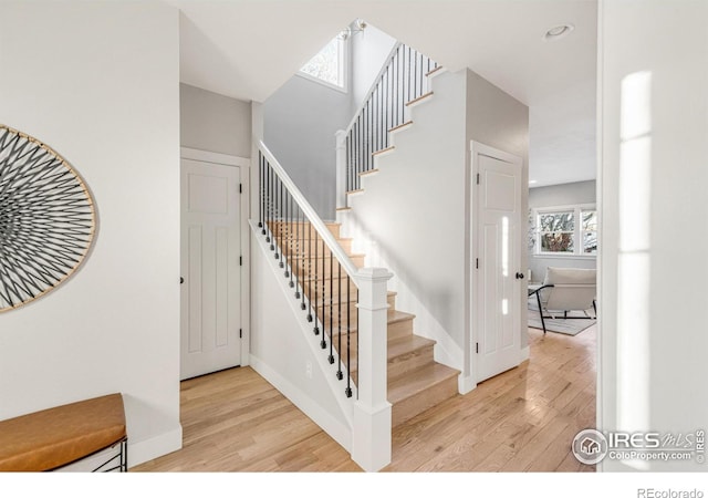 stairs featuring hardwood / wood-style flooring and a healthy amount of sunlight