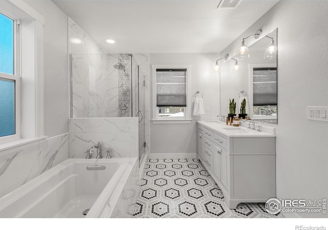 bathroom with vanity and shower with separate bathtub