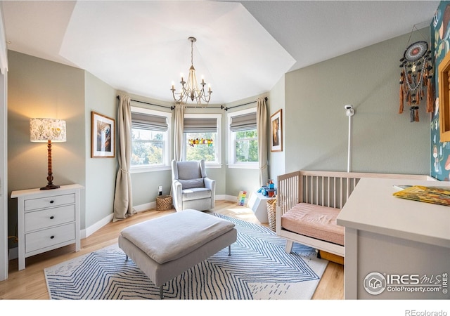 living area with an inviting chandelier and light hardwood / wood-style flooring