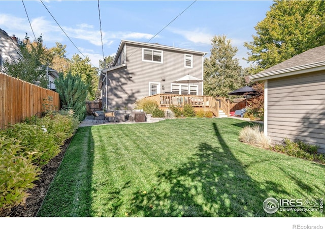 back of house featuring a wooden deck, a yard, and a patio area