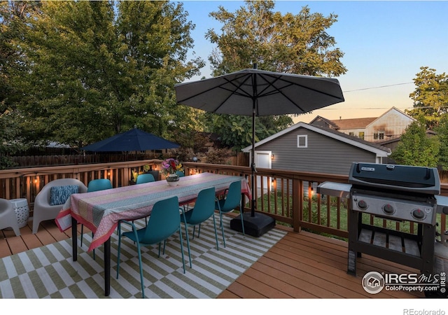 deck at dusk with an outbuilding and grilling area