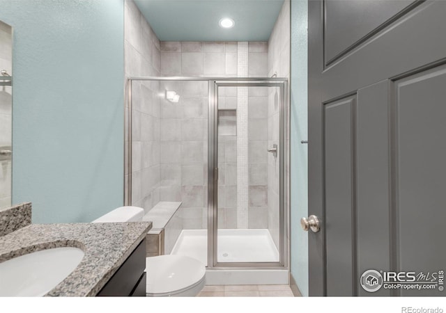 bathroom with vanity, a shower with shower door, and toilet