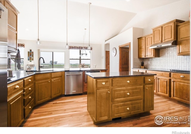 kitchen featuring a kitchen island, lofted ceiling, sink, decorative backsplash, and stainless steel dishwasher