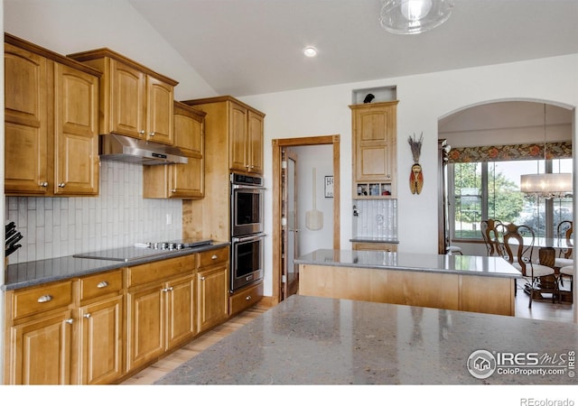 kitchen with tasteful backsplash, a center island, dark stone countertops, black electric cooktop, and stainless steel double oven