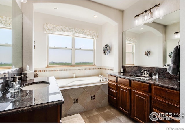 bathroom with vanity, tiled tub, and tile patterned floors