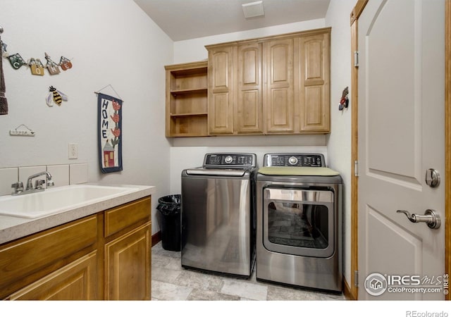 washroom featuring cabinets, sink, and independent washer and dryer