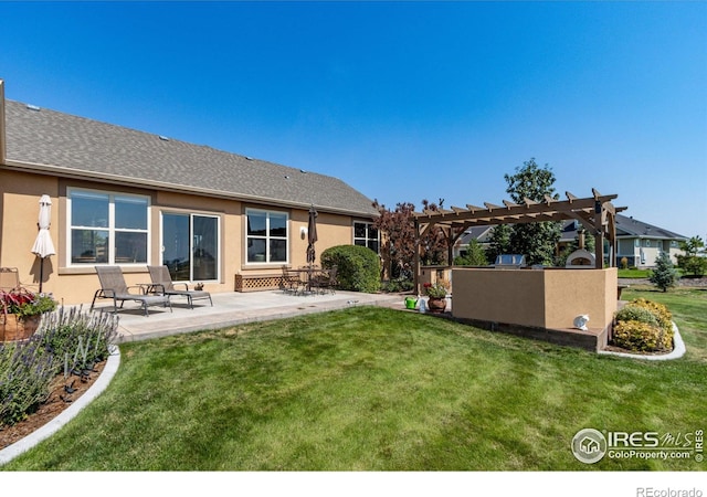 back of property with a patio, a lawn, and a pergola