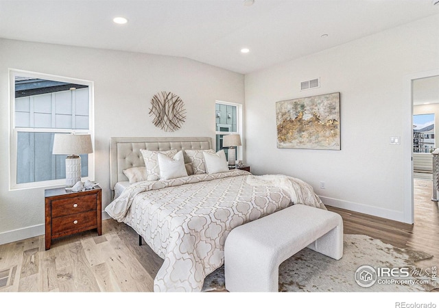 bedroom with light hardwood / wood-style floors and vaulted ceiling