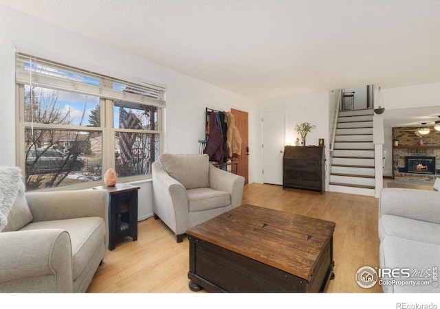 living room with a fireplace and light wood-type flooring