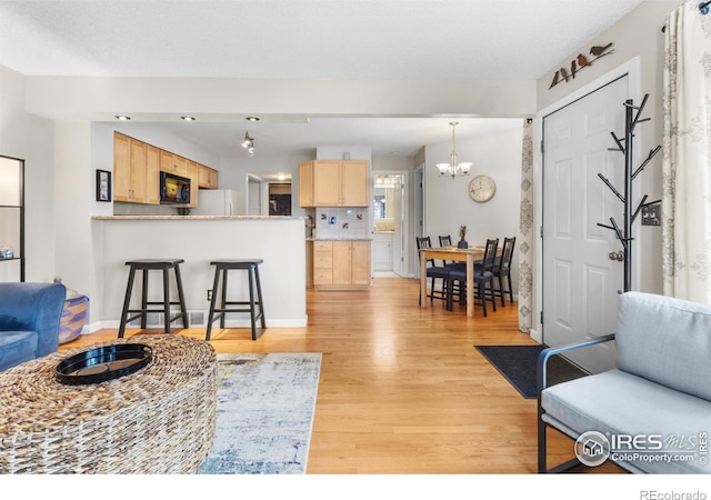 living room with a notable chandelier and light hardwood / wood-style flooring