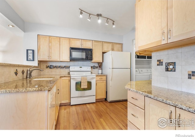 kitchen with sink, white appliances, backsplash, washing machine and dryer, and light brown cabinetry