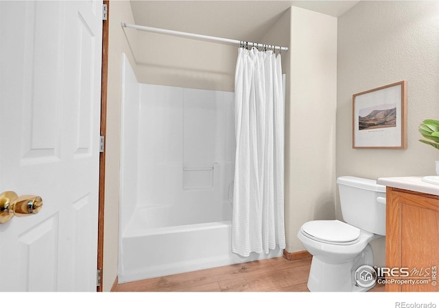 full bathroom featuring vanity, hardwood / wood-style flooring, toilet, and shower / bath combo with shower curtain