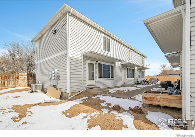 snow covered property with central air condition unit