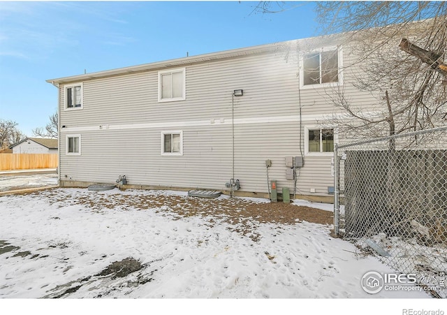 view of snow covered rear of property