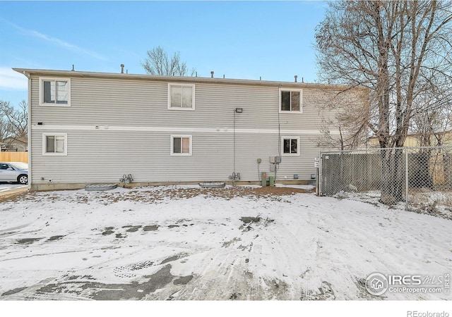 view of snow covered rear of property