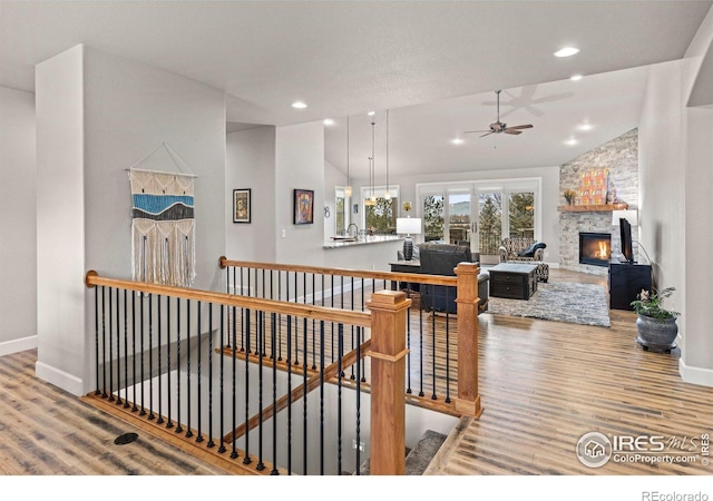 interior space with wood-type flooring, lofted ceiling, and a fireplace