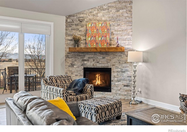 living room with a fireplace, vaulted ceiling, and hardwood / wood-style floors