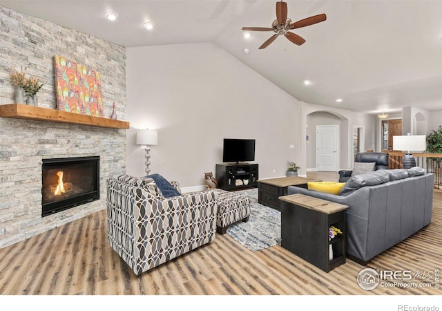 living room featuring ceiling fan, lofted ceiling, and a fireplace