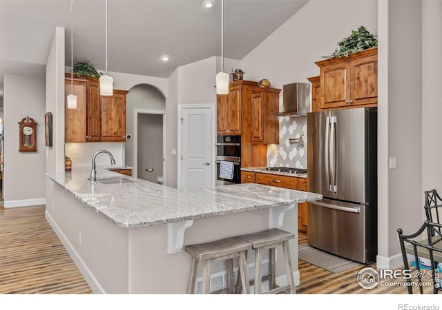 kitchen with sink, tasteful backsplash, decorative light fixtures, kitchen peninsula, and stainless steel appliances