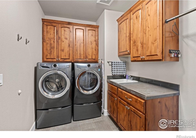 clothes washing area with independent washer and dryer, cabinets, light tile patterned flooring, and sink