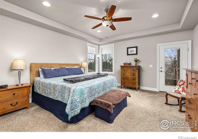 bedroom with light carpet, access to outside, a raised ceiling, and ceiling fan