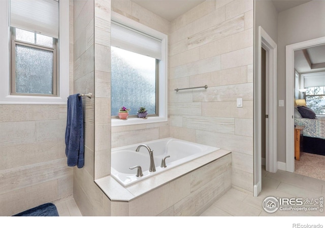 bathroom with tile patterned flooring and tiled tub