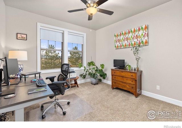 carpeted home office featuring ceiling fan