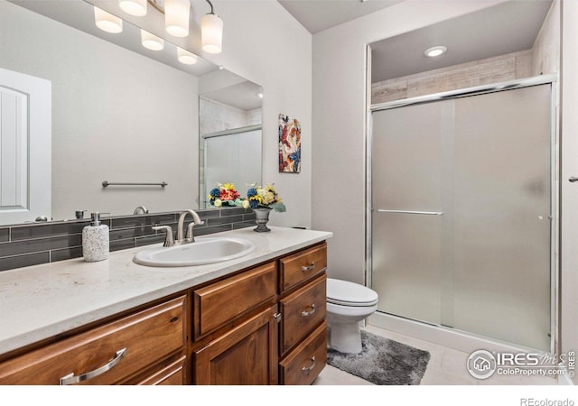 bathroom with vanity, tile patterned flooring, a shower with door, and toilet