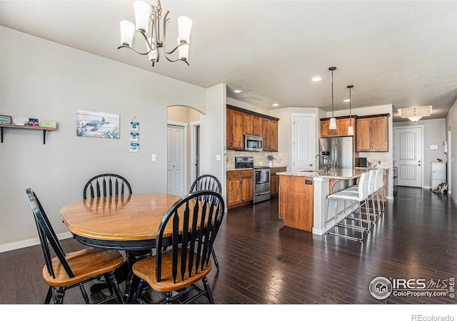 dining space featuring dark hardwood / wood-style floors, sink, and a notable chandelier