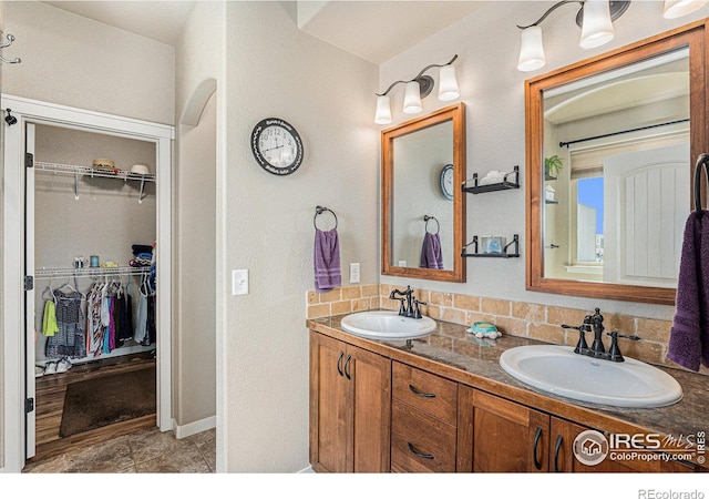 bathroom featuring vanity and backsplash