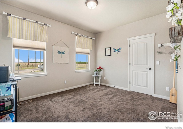 miscellaneous room featuring dark colored carpet