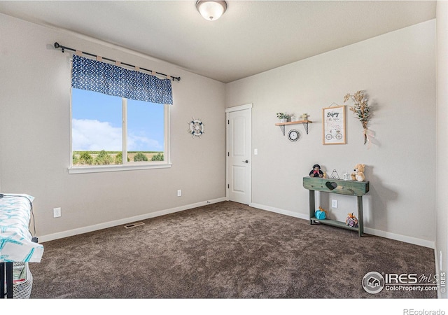 misc room featuring dark colored carpet