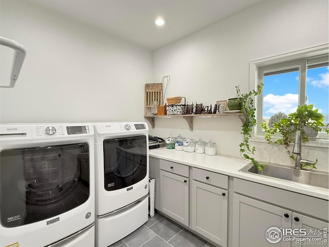 washroom with tile patterned flooring, sink, cabinets, and washer and clothes dryer