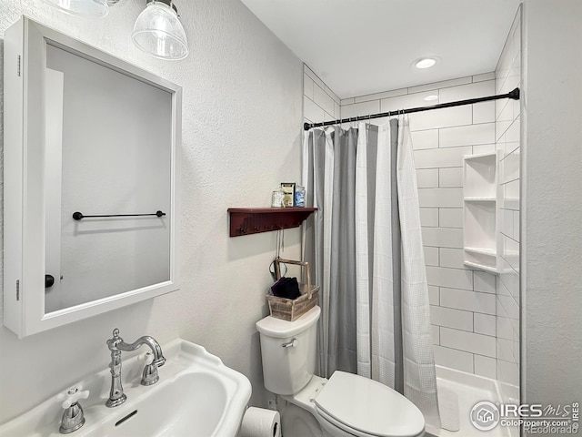 bathroom featuring toilet, curtained shower, and sink