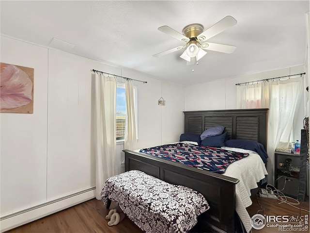 bedroom featuring dark hardwood / wood-style floors, ceiling fan, and baseboard heating