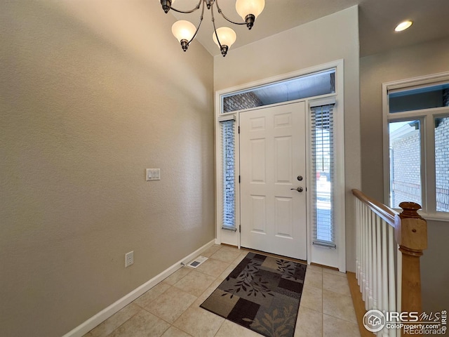 tiled entrance foyer featuring a chandelier