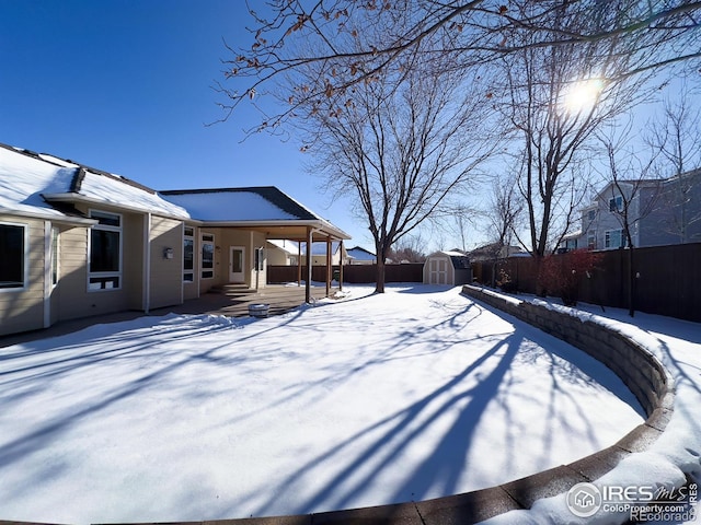 snowy yard featuring a shed