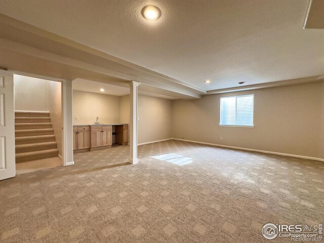 basement with sink and light colored carpet