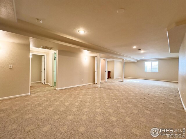 basement featuring light colored carpet