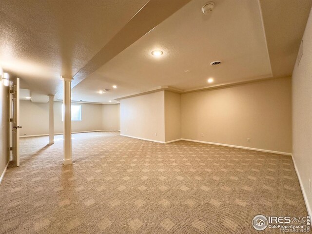 basement featuring a textured ceiling and carpet