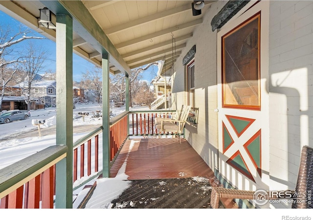 snow covered deck with covered porch