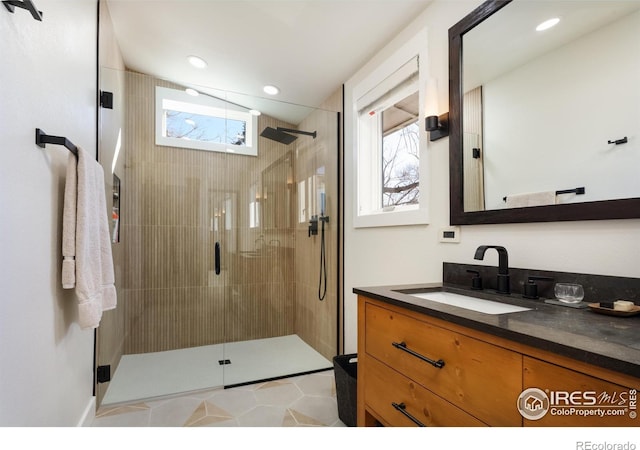 bathroom with a shower with door and vanity