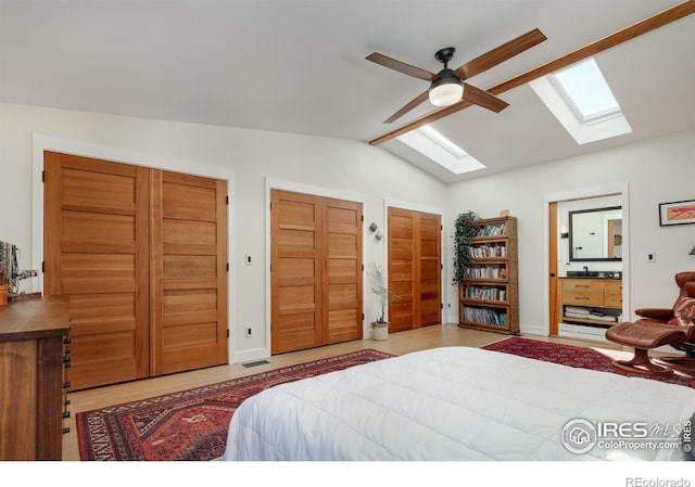 bedroom with vaulted ceiling, connected bathroom, two closets, and ceiling fan