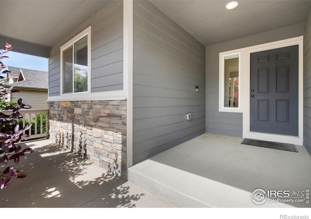 1484 First Light Dr, Windsor, CO 80550 - view of exterior entry featuring a porch and stone siding